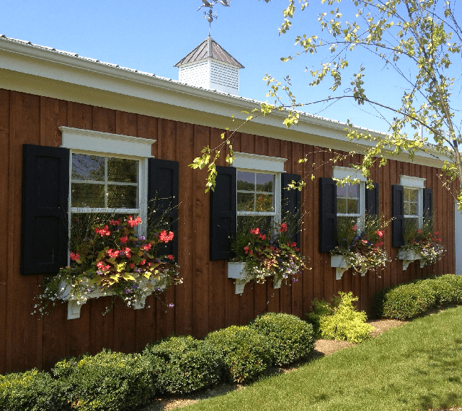 a charming wooden building with a row of windows on the side. Each window is adorned with a colorful flower box, adding a vibrant touch to the exterior a charming wooden building with a row of windows on the side. Each window is adorned with a colorful flower box, adding a vibrant touch to the exterior